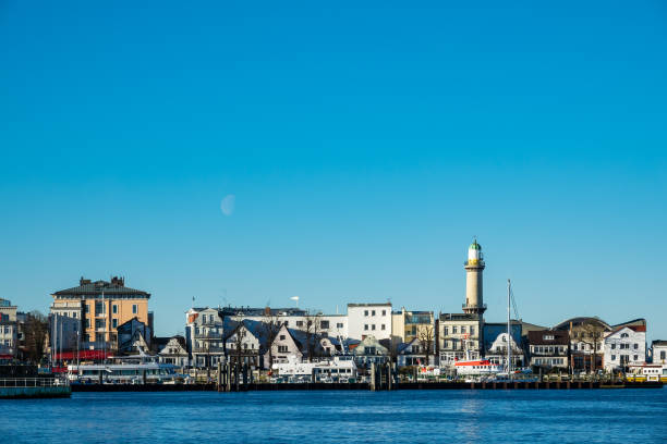 istock Buildings, lighthouse and blue sky in Warnemuende, Germany 1148425326