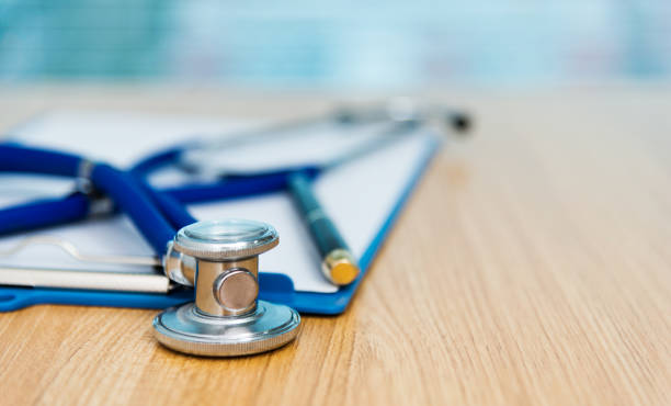 istock Clipboard with stethoscope and pen on desk 1148429415