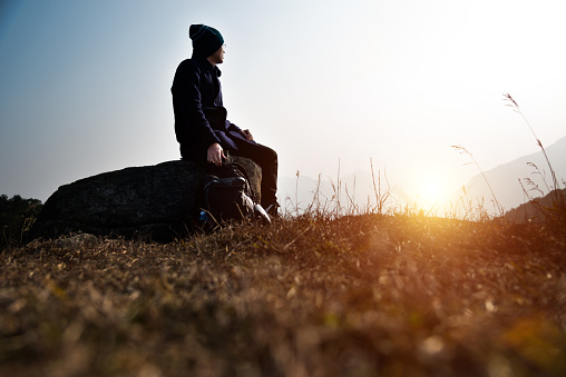 A man sitting on top of mountain.