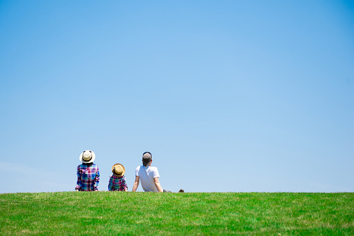 Father and mother and daughter playing in the meadow