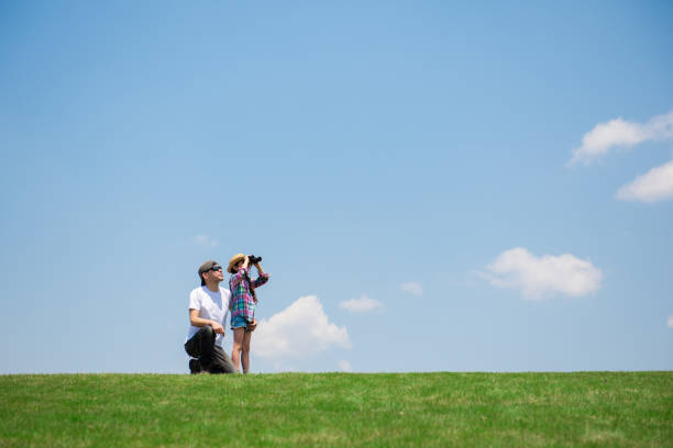 Father and daughter looking afar with binoculars