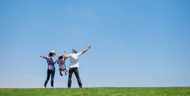 ojciec i matka i córka bawią się na łące - outdoors playing family spring zdjęcia i obrazy z banku zdjęć