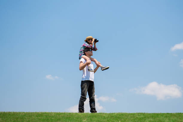 istock Father and daughter looking afar with binoculars 1148432027