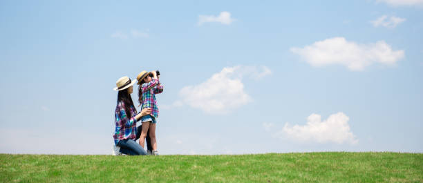 istock Mother and daughter looking afar with binoculars 1148432068