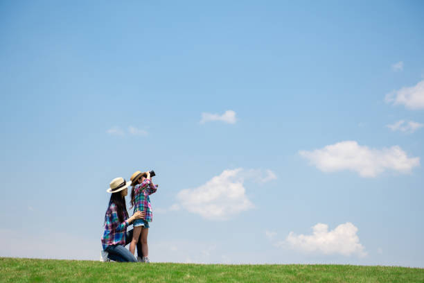 Mother and daughter looking afar with binoculars