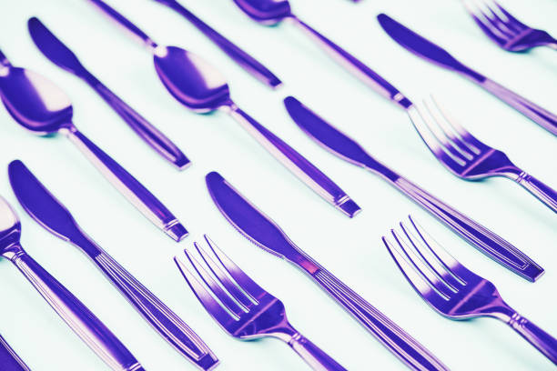 istock Flat lay background with purple forks, knives and spoons 1148437154