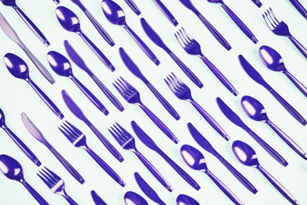 istock Flat lay background with purple forks, knives and spoons 1148437158
