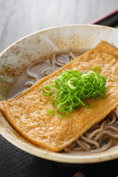 Soba. Buckwheat noodles.Japanese food.
 Soba noodles in a hot soup with deep-fried tofu