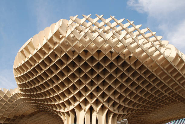 Seville, Spain - April 2, 2019: People walk under the Metropol Parasol (by architect Jurgen Mayer H) known as Las Setas de Sevilla (Mushrooms of Seville). Completed in 2011, it is said to be the largest wooden structure in the World.