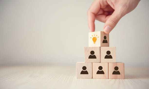 istock Leader with idea and innovation, Woman hand flips cube with icon light bulb and human symbol. 1148441272