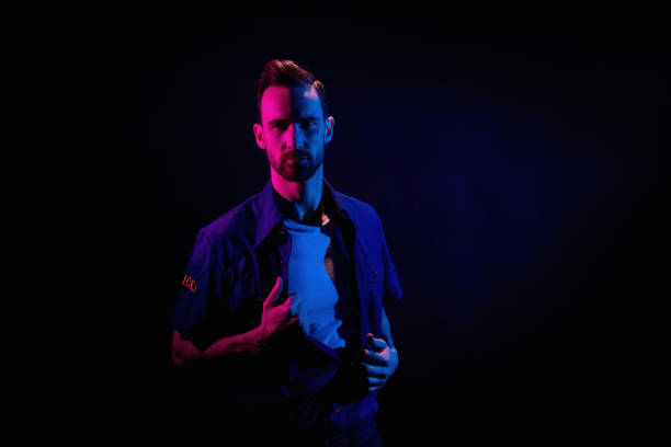 istock Handsome man on black background with red and blue lighting 1148442791