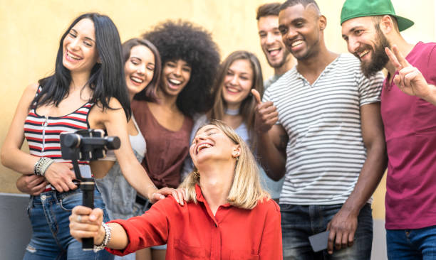 istock Multiracial young friends taking selfie with mobile smart phone and stabilizer gimbal - Friendship concept with millenial people having fun together sharing live feeds on social media networks 1148445732