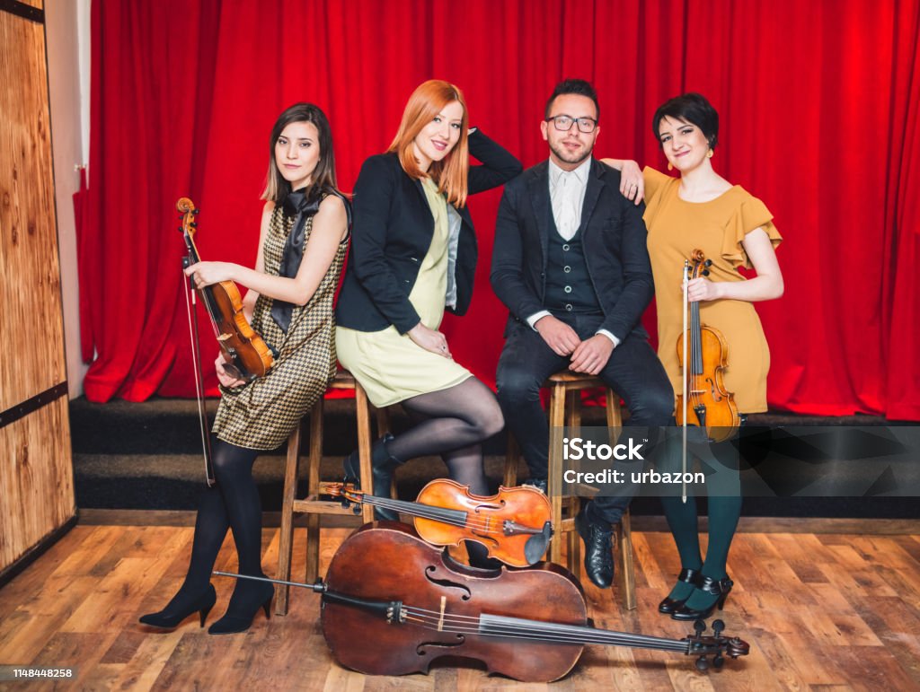 String Quartet Positioning String Quartet Posing After The Concert With Their Instruments On Stage ...