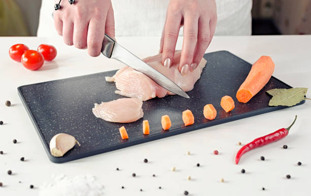 istock girl cuts chicken meat into small slices on a black cutting board 1148448977