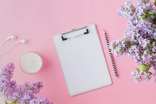 istock Flat lay blogger or freelancer workspace with a mockup clipboard and branches of lilac on a pink background 1148450628