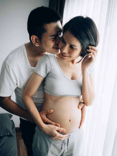 joli couple. appréciant la maison préparant pour le bébé - rubbing human hand togetherness women photos et images de collection