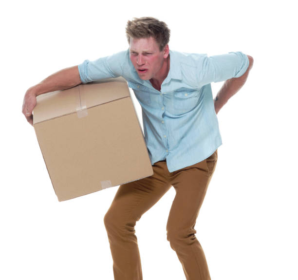 istock Good looking man holding a brown box and has back pain 1148452800