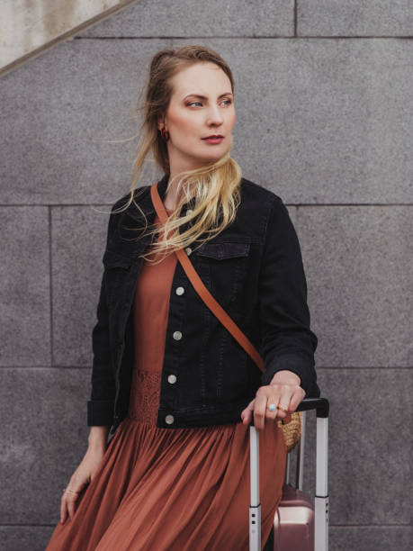 istock Woman with luggage suitcases 1148453861