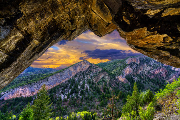 Rock Cave High in Canyon Wall - Scenic views looking across valley to rugged cliffs and mountain.