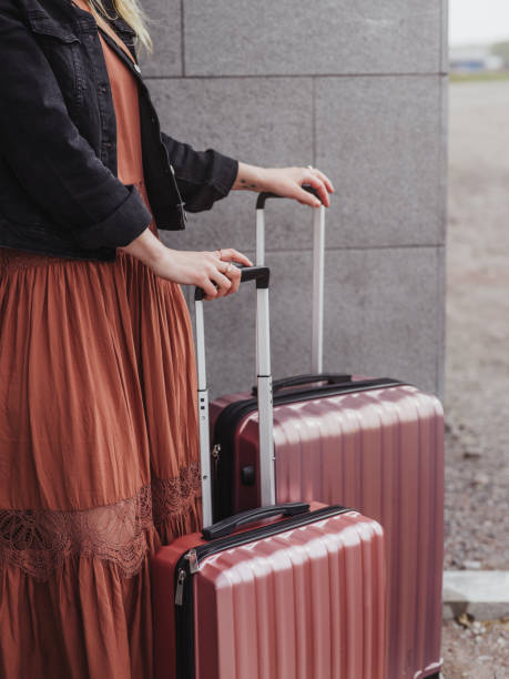 istock Woman with luggage suitcases 1148458296