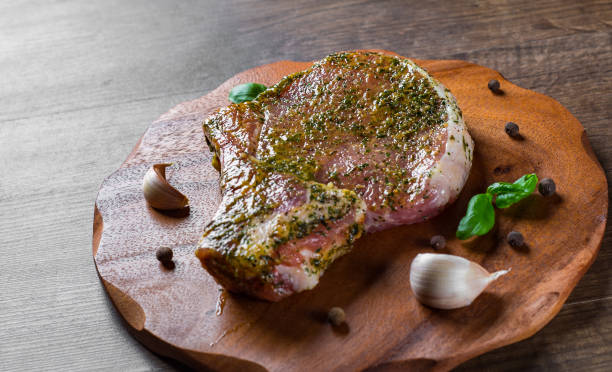 istock Raw Pork Loin chops marinated meat Steak for bbq on wooden table background 1148460660