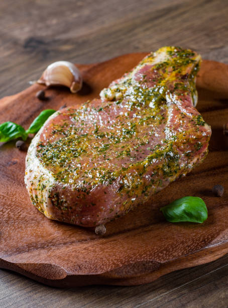 istock Raw Pork Loin chops marinated meat Steak for bbq on wooden table background 1148460676