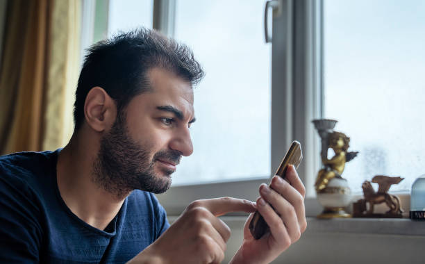istock Man text messaging on mobile phone at home 1148473229