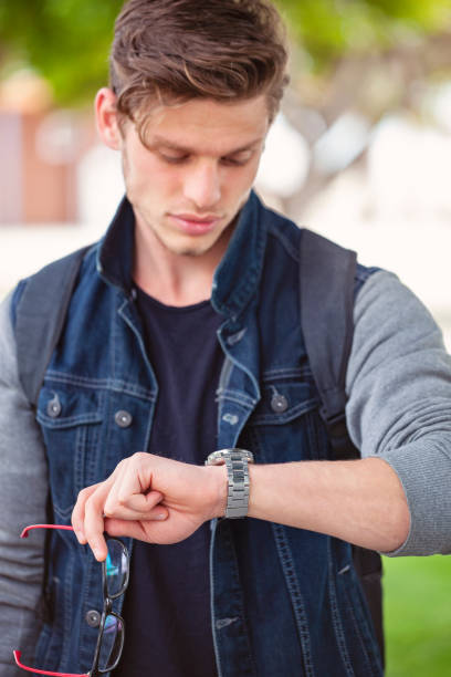 istock Young student walking in the city and checking time. 1148490535