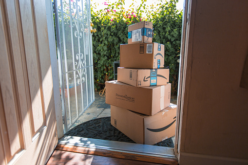 Los Angeles CA, November 11/22/2017: Image of an Amazon packages. Amazon is an online company and is the largest retailer in the world. Cardboard package delivery at front door during the holiday season. shipping package parcel box on wooden floor with protection paper inside. Amazon.com went online in 1995 and is now the largest online retailer in the world.