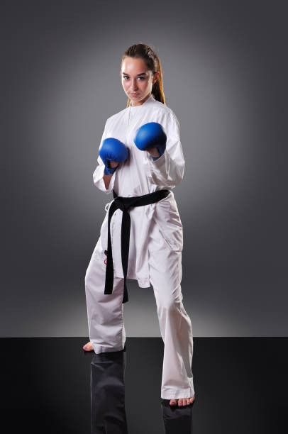 istock Beautiful young female karate player posing on the gray background 1148491569