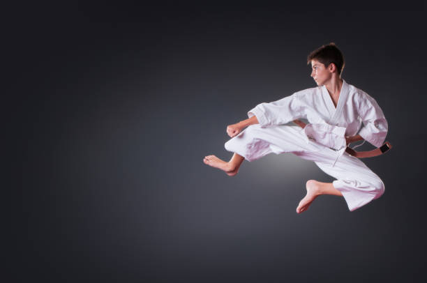istock Handsome young male karate player doing kick on the gray background 1148491662
