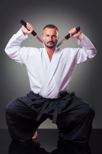 istock Handsome male karate player posing with the sword on the gray background. 1148491930