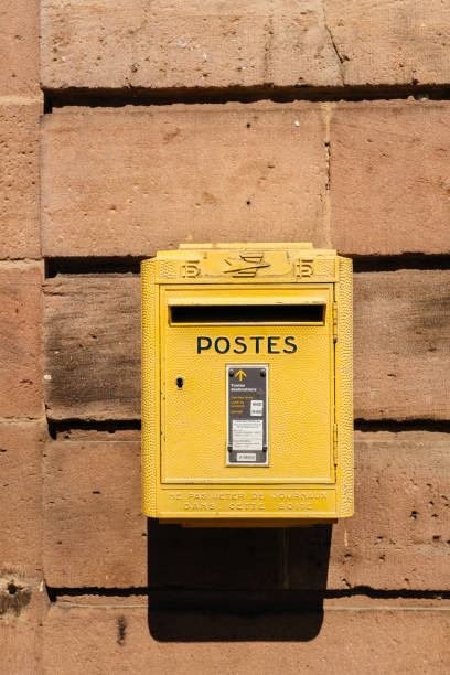 Bergheim, France - 19 Apr 2019: Old vintage French La Poste mailbox painted in yellow color seen on the walls of Bergheim city-hall