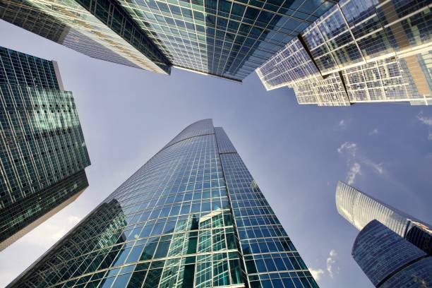 escritórios e arranha-céus residenciais de encontro ao céu azul desobstruído brilhante - glass facade copy space skyscraper - fotografias e filmes do acervo