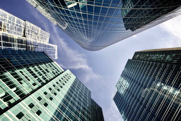 High-tech facade design Office and residential skyscrapers against bright clear blue sky. Commercial real estate. Glass and metal in urban architecture. Modern facade design. Modern business city district. Office buildings exterior. Financial city district. Reflections and highlights in glass. Wide angle city photography. commercial real estate stock pictures, royalty-free photos & images