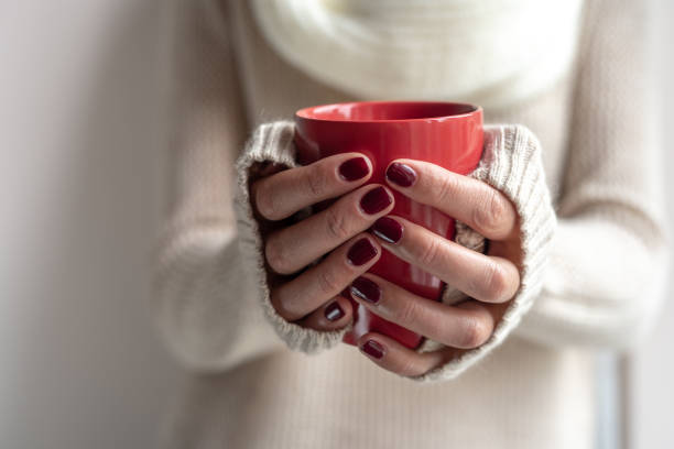 istock Young woman holds a cup with a hot drink in her hands. 1148500220
