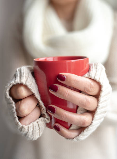 istock Young woman holds a cup with a hot drink in her hands. 1148500221