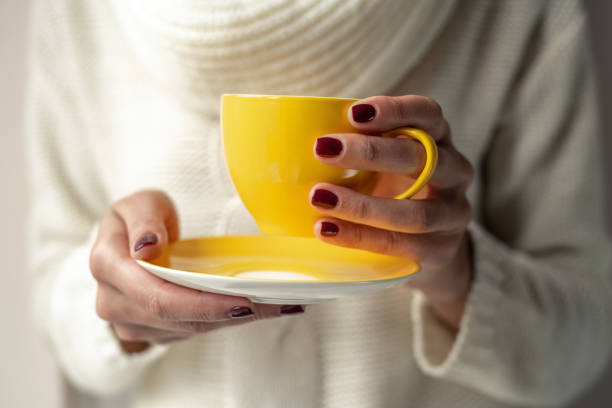 istock Young woman holds a cup with a hot drink in her hands. 1148500224