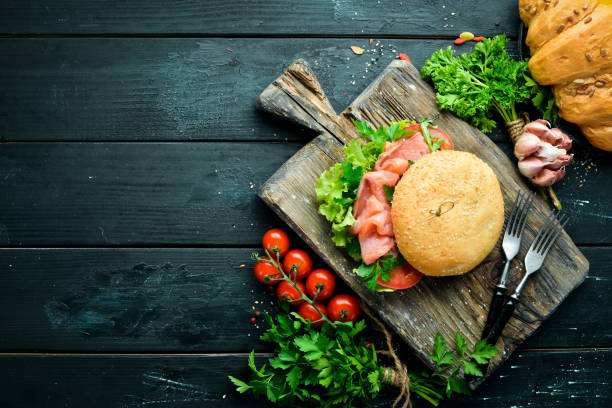 istock Burger with salmon, tomatoes and onions. Breakfast. Top view. Free space for your text. 1148502479