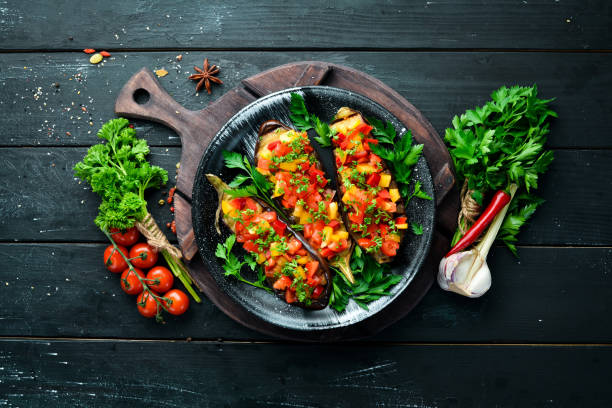 istock Eggplants baked with vegetables on a black plate. Top view. Free space for your text. 1148502699