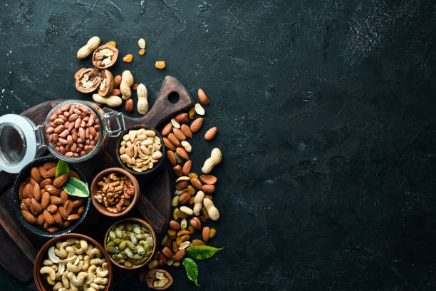 istock Assorted nuts on the old black background. Top view. Free space for your text. 1148503388