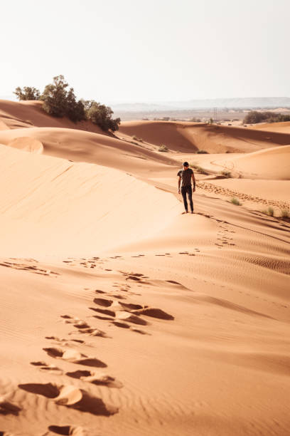 istock man walking in the desert sahara at dusk in morocco 1148508157