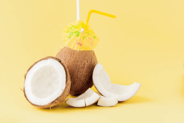istock Fresh Coconut cocktail with a straws on yellow background, copy space 1148514381