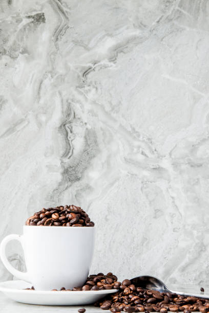 istock Black coffee in cup and coffee beans on marble background. Top view, space for text 1148517821