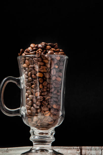 istock Black coffee in white cup and coffee beans on black background. Top view, space for text 1148517830