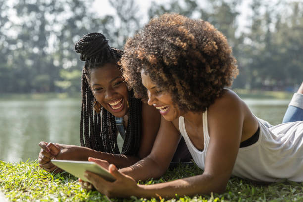 istock Young afro woman using tablet in the park 1148519643