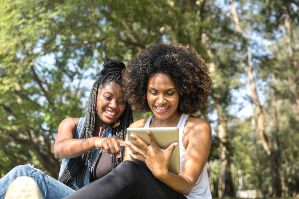 istock Young latinx woman using tablet in the park 1148519644