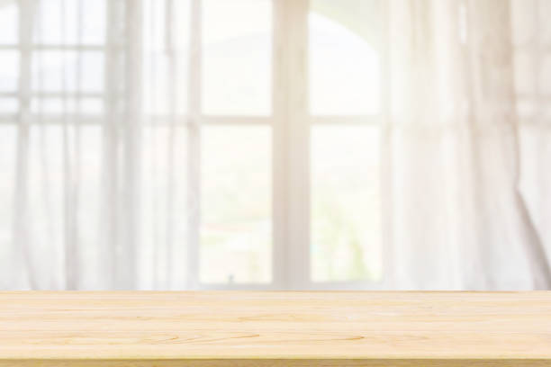 istock Empty wood table top with window curtain abstract blur background for product display 1148520676
