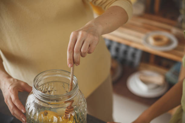 istock Woman stirring lemonade with honey dipper 1148520739