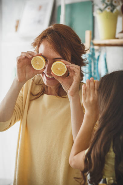istock Mother and daughter playing with lemons 1148520759
